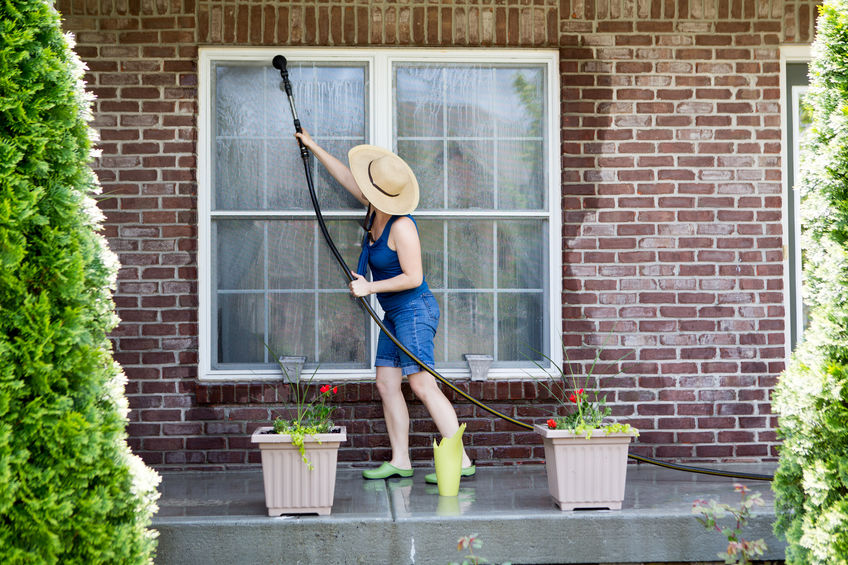 Housewife washing the windows of her house